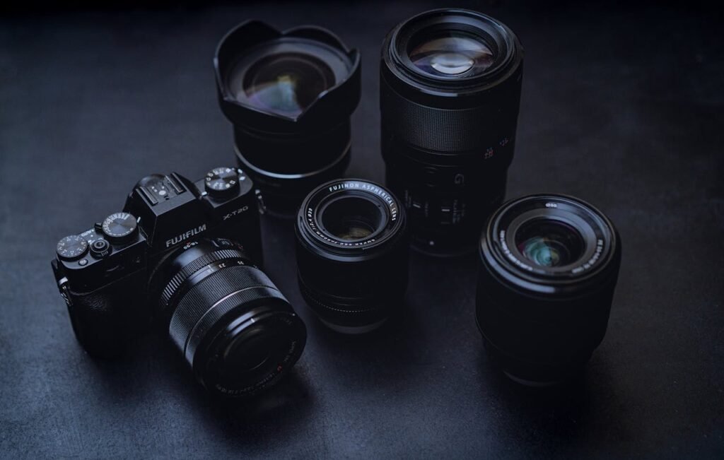 From above of modern digital photo camera placed on black table near various professional lenses